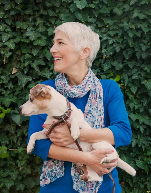 A woman carrying her dog in the central park